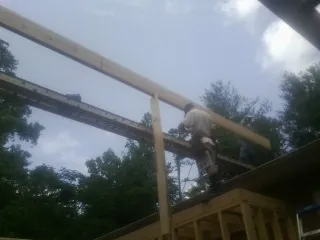 Carpenter setting a ridge beam over a new addition frame — Ice Dam Removal by Roofing Brothers in Rixeyville