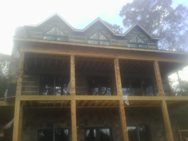 Dormers and porch framing on a large log home under construction — Roof Coating work by our crew in Rixeyville
