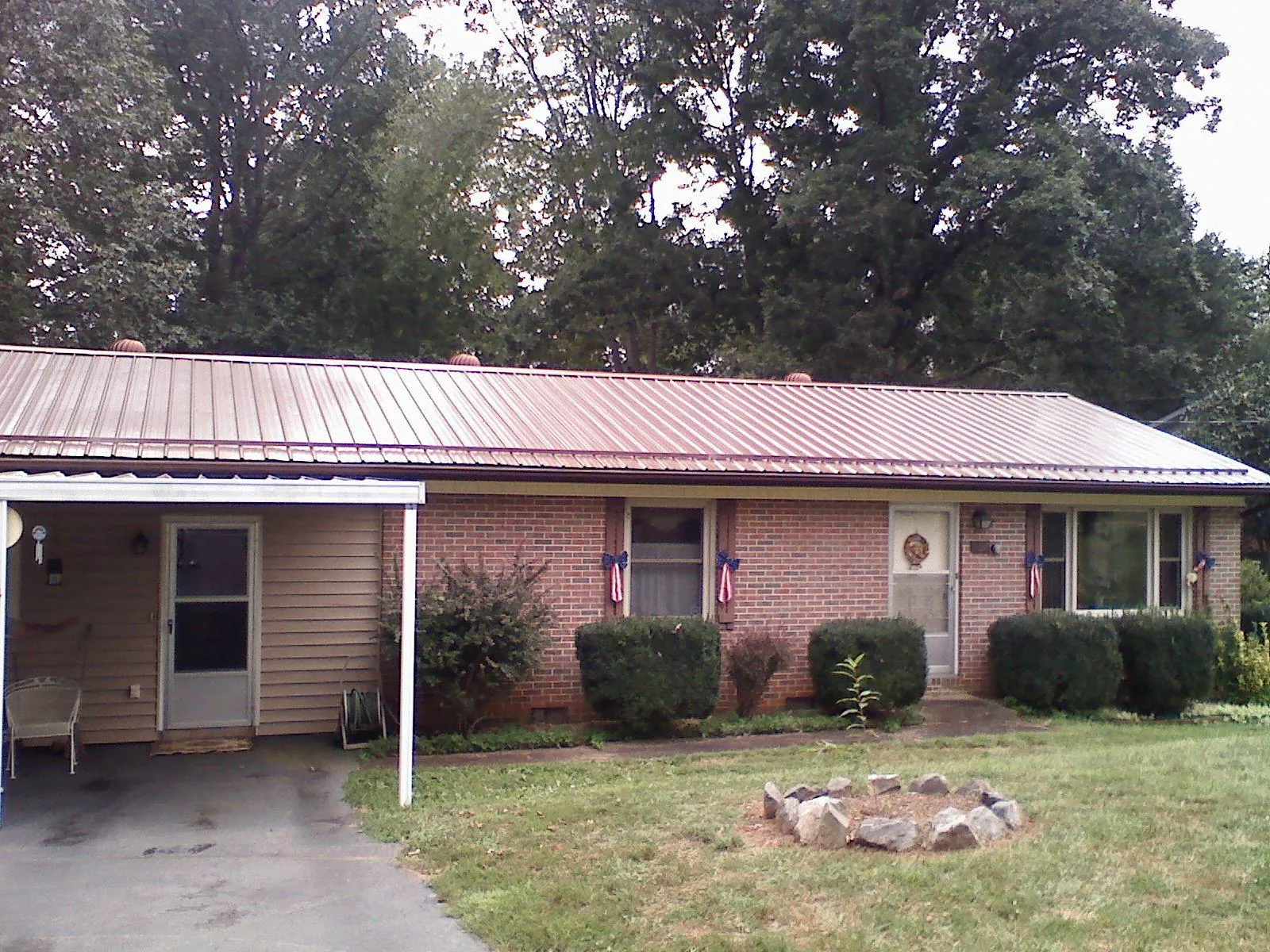Bronze metal roof and carport on a brick ranch home — Roof Repair work by our crew in Rixeyville